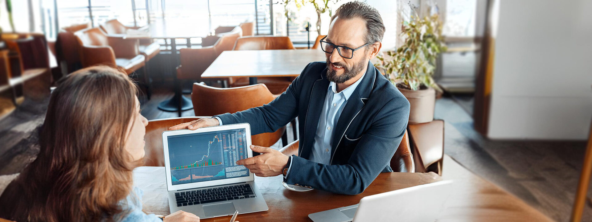 business man showing charts on computer to woman