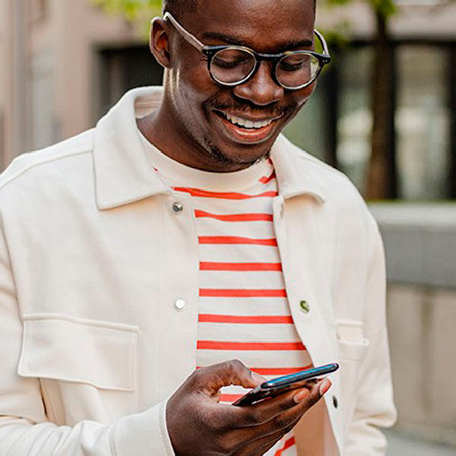Hombre sonriendo mirando su smartphone