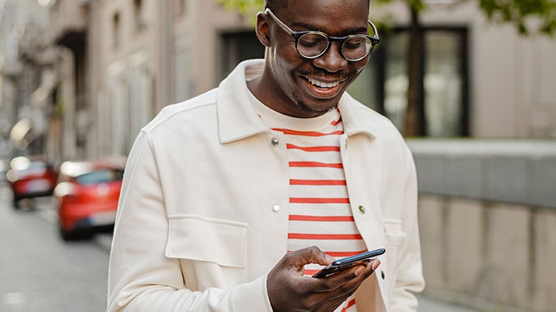 Hombre sonriendo mirando su smartphone