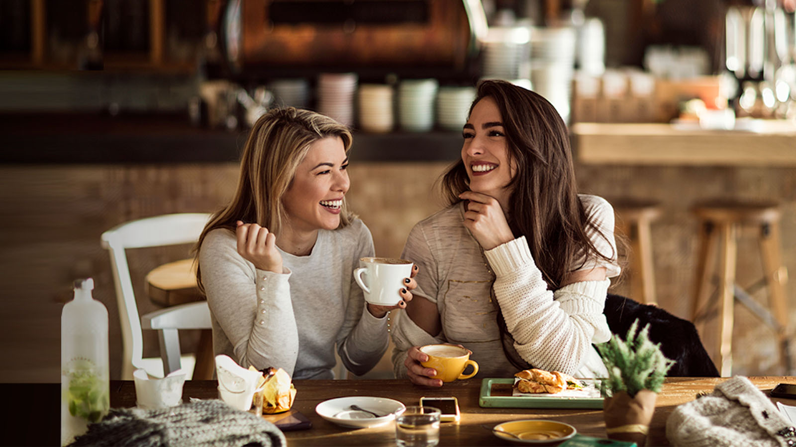 Mujeres sonrientes compartiendo un desayuno 